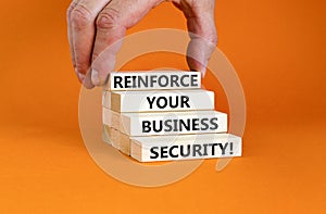 Reinforce your business security symbol. Concept word Reinforce your business security on blocks. Beautiful orange background.