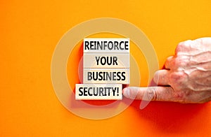 Reinforce your business security symbol. Concept word Reinforce your business security on blocks. Beautiful orange background.