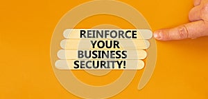 Reinforce your business security symbol. Concept word Reinforce your business security on sticks. Beautiful orange background.