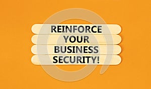 Reinforce your business security symbol. Concept word Reinforce your business security on sticks. Beautiful orange background.