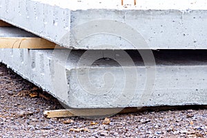reinforced concrete slabs lie on wooden spacers awaiting installation in accordance with a construction project