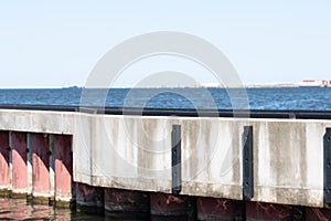 Reinforced concrete structure with metal pink pipes in the sea. Copy space