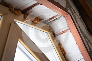 Reinforced reinforced window opening. Plastic window with wood imitation mounted on an aerated concrete block wall photo