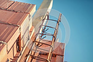 Reinforcement steel bars on pillars and layers of bricks on new house construction