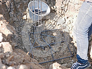 Reinforcing steel being placed into a footing hole getting ready for concrete placement - placing reinforce bars