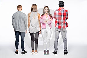 Reir view of a casual group of people with a girl facing the camera isolated on white photo