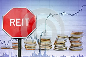 REIT sign on economy background with graph and coins