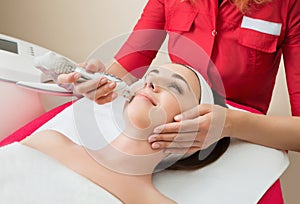 Rejuvenating facial treatment. Model getting lifting therapy massage in a beauty SPA salon