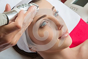 Rejuvenating facial treatment. Model getting lifting therapy massage in a beauty SPA salon