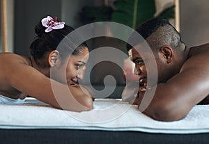 Rekindle your love with a little relaxation. a young couple relaxing on massage beds at a spa.