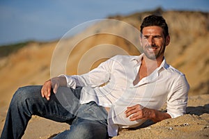 Relalaxed man seated on the sand