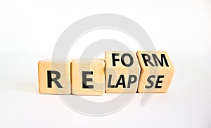 Relapse or reform symbol. Turned wooden cubes and changed the word `relapse` to `reform`. Beautiful white background. Business