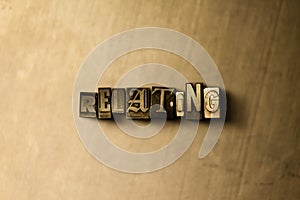 RELATING - close-up of grungy vintage typeset word on metal backdrop