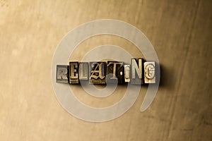 RELATING - close-up of grungy vintage typeset word on metal backdrop photo
