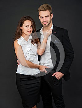 relations of formal couple in love in business look on black background, cooperation