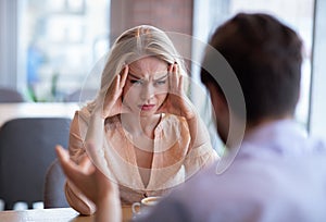 Relationship problems, divorce, separation concept. Unhappy young woman having conflict with her boyfriend at cafe