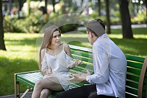 Relationship problems. Millennial couple having argument on bench at summer park