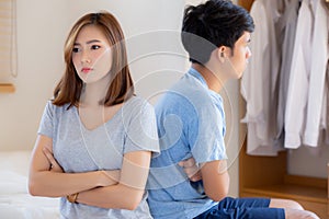 Relationship of young asian couple having problem on bed in the bedroom at home, family having conflict argument with unhappy