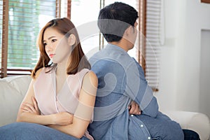 Relationship of young asian couple having problem on sofa in the living room at home