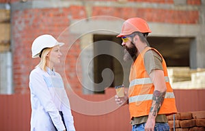 Relationships between construction clients and participants of building industry. Woman engineer and brutal builder