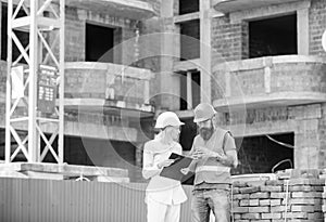 Relationships between construction clients and participants building industry. Woman engineer and builder communicate at