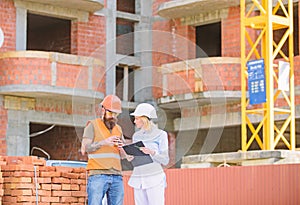 Relationships between construction clients and participants building industry. Woman engineer and builder communicate at