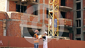 Relationships between construction clients and participants building industry. Woman engineer and builder communicate at