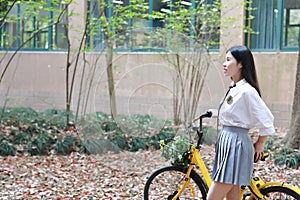 Relax Asian Chinese pretty girls wear student suit in school enjoy free time ride bike in nature spring garden