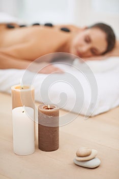 Relax, candles and woman with hot stone massage at spa for health, wellness or luxury holistic treatment. Self care