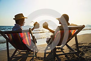 Relax couple lay down on beach chiar with sea wave background