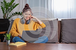 Relax, de-stress, holiday, happy, Asian woman relaxing at home listening to music from smartphone and laptop happily