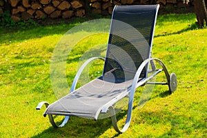 Relax. Empty deck chair on grass in garden.