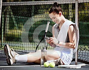Relax, fit and phone with woman tennis player browsing, social media or web outdoor on the court. A happy young female