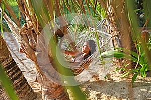 Relax happy woman on cradle or hammock beach background beautiful sunset sunrise and coconut