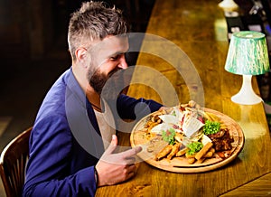 Relax after hard working day. Businessman formal suit sit at bar counter. Man received meal with fried potato fish