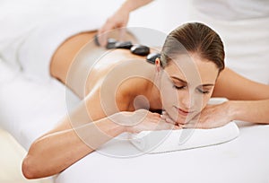 Relax, hot stone massage and girl at spa for health, wellness and luxury holistic treatment. Self care, zen and woman in