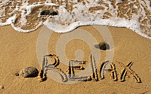 Relax - the inscription on the sand near the ocean