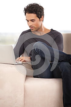 Relax, laptop and online with man on sofa for social media, networking and connection. Website, streaming and digital