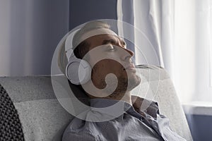Relax or meditation man listening to music on his wireless headphones at home.