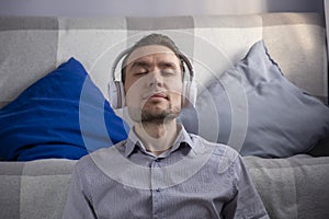 Relax or meditation man listening to music on his wireless headphones at home.