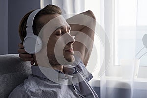 Relax or meditation man listening to music on his wireless headphones at home.