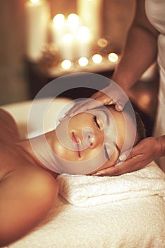 Relax with a pampering spa treatment. Closeup shot of a young woman enjoying a head massage at the spa.
