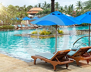 Relax by The Pool in Luxury Hotel on The Island of Thailand. Couple of Wooden Chair under The Umbrella