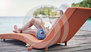 Relax, reading and travel with woman at hotel resort for summer vacation, peace and tropical. Books, luxury and holiday