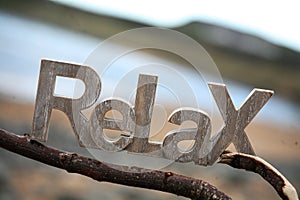 Relax Sign in on driftwood by the sea