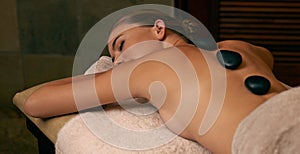 Relax, spa and woman with hot stone back massage for health, wellness and beauty routine. Body care, calm and female