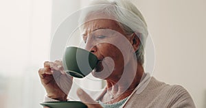Relax, tea and a senior woman drinking from a cup in the living room of her nursing home during retirement. Face, smile