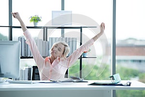 Relax time.  Successful Businesswoman relaxing raise arm after sitting and hard working in modern office.