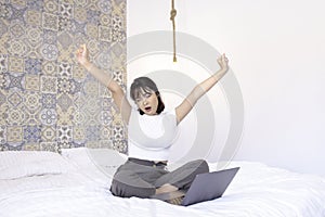 Relax and tired asian beautiful girl work the laptop in the bed. Work from home concept