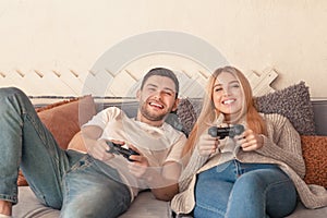 Happy couple holding joysticks and playing video game